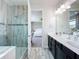 Bright bathroom with a glass-enclosed shower, double sinks, and a doorway leading to the bedroom at 4993 Southlawn Ave, Orlando, FL 32811