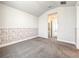 Empty bedroom featuring neutral carpet, patterned wainscoting, and an ensuite bathroom entrance at 4993 Southlawn Ave, Orlando, FL 32811