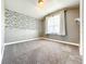 Charming bedroom featuring playful wallpaper, neutral carpet, and bright natural light from a large window at 4993 Southlawn Ave, Orlando, FL 32811