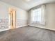 Bright bedroom featuring neutral carpet, patterned wainscoting, and a window with flowing curtains at 4993 Southlawn Ave, Orlando, FL 32811