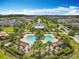 Aerial view of a community pool with palm trees, cabanas, and a surrounding fence in a residential area at 4993 Southlawn Ave, Orlando, FL 32811