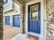 Inviting front entrance featuring a stone pillar, blue door with window, and brick walkway at 4993 Southlawn Ave, Orlando, FL 32811