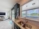 Gourmet kitchen with granite countertops, stainless sink, tile backsplash, and an open view to the living room and lake at 4993 Southlawn Ave, Orlando, FL 32811