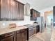 Gourmet kitchen features dark cabinets, stainless steel appliances, and granite countertops at 4993 Southlawn Ave, Orlando, FL 32811