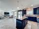 Open-concept kitchen and living area featuring a granite island and stainless appliances at 4993 Southlawn Ave, Orlando, FL 32811