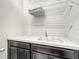 Bright laundry area featuring a sink with modern faucet, crisp counter, and convenient overhead storage shelves at 4993 Southlawn Ave, Orlando, FL 32811