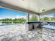 Outdoor kitchen featuring a built-in grill, refrigerator, and bar seating overlooking the pool and lake at 4993 Southlawn Ave, Orlando, FL 32811