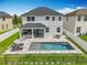 A backyard swimming pool with an outdoor kitchen and patio set, enclosed with a black metal fence at 4993 Southlawn Ave, Orlando, FL 32811