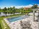 Backyard with swimming pool, patio table set, and lounge chairs overlooking a scenic lake view at 4993 Southlawn Ave, Orlando, FL 32811