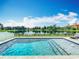 Sparkling pool with fountains and lounge chair overlooking beautiful lake view in backyard at 4993 Southlawn Ave, Orlando, FL 32811