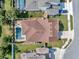 Aerial view of a home with a backyard pool, well-maintained landscaping, and a spacious layout in a residential area at 5018 Tupelo Ct, Minneola, FL 34715
