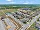 Aerial view features houses, tennis courts, a parking lot and a recreational field at 5018 Tupelo Ct, Minneola, FL 34715