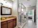 Bathroom with a glass enclosed shower, granite counters, and tile floors at 5018 Tupelo Ct, Minneola, FL 34715