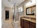 Bathroom featuring a glass shower, granite counters, and a walk-in closet at 5018 Tupelo Ct, Minneola, FL 34715
