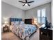 Bedroom featuring a bed with a patterned comforter, ceiling fan, and shuttered windows at 5018 Tupelo Ct, Minneola, FL 34715
