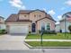 Beautiful two-story home with a well manicured lawn, attached garage, and a blue front door at 5018 Tupelo Ct, Minneola, FL 34715