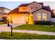 Charming stucco home featuring a two-car garage, a manicured lawn, and arched windows at 5018 Tupelo Ct, Minneola, FL 34715