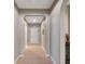 Bright hallway featuring neutral walls, arched doorways, and tile flooring leading to a white front door at 5018 Tupelo Ct, Minneola, FL 34715