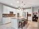 Modern kitchen features white cabinets, stainless appliances, and a central island with seating at 5018 Tupelo Ct, Minneola, FL 34715