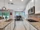 Kitchen with granite countertops, stainless appliances, and a sink overlooking the dining area and living room at 5018 Tupelo Ct, Minneola, FL 34715
