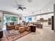 Open-concept living room featuring tile floors and a ceiling fan that flows into the kitchen and dining areas at 5018 Tupelo Ct, Minneola, FL 34715