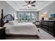Spacious bedroom featuring a tray ceiling, ample natural light, and elegant furnishings at 5018 Tupelo Ct, Minneola, FL 34715