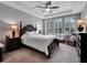 Serene bedroom with tray ceiling, large windows, and comfortable seating area at 5018 Tupelo Ct, Minneola, FL 34715