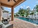 Back yard with an outdoor patio and in-ground pool surrounded by palm trees and landscaping at 5018 Tupelo Ct, Minneola, FL 34715