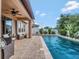 Back yard featuring an in-ground pool, manicured tropical landscaping and outdoor seating at 5018 Tupelo Ct, Minneola, FL 34715