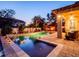 Backyard pool area featuring brick pavers, tropical landscaping, lighting and a comfortable patio set at 5018 Tupelo Ct, Minneola, FL 34715