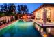 Nighttime backyard with a glowing pool and elegant patio, providing a serene and luxurious outdoor setting at 5018 Tupelo Ct, Minneola, FL 34715