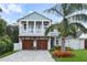 Beautiful two-story home with a two-car garage, paver driveway, palm tree, and front-facing balcony at 507 S Pine St, New Smyrna Beach, FL 32169