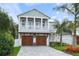 Beautiful two-story home featuring a spacious front porch and a well-manicured lawn with lush landscaping and a paved driveway at 507 S Pine St, New Smyrna Beach, FL 32169