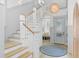 Bright foyer showcases staircase, stylish light fixture, bench seating under window and a decorative entry door at 507 S Pine St, New Smyrna Beach, FL 32169