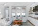 Bright living room featuring white sofas, shiplap walls, and large windows at 507 S Pine St, New Smyrna Beach, FL 32169
