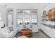 Bright living room featuring white sofas, shiplap walls, and large windows at 507 S Pine St, New Smyrna Beach, FL 32169