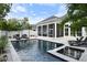 Inviting backyard with a large, dark bottom pool, tanning chairs and a screened in lanai at 507 S Pine St, New Smyrna Beach, FL 32169
