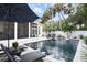 Relaxing backyard pool area with comfortable lounge chairs, lush landscaping, and a screened-in patio at 507 S Pine St, New Smyrna Beach, FL 32169