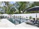 Lush backyard with a dark bottom pool, poolside loungers, landscaping and plenty of room to relax at 507 S Pine St, New Smyrna Beach, FL 32169