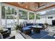 Enclosed porch with an outdoor seating area, blue cushions, a ceiling fan, and view of pool at 507 S Pine St, New Smyrna Beach, FL 32169