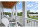 A covered porch with columns featuring white Adirondack chairs and a wooden ceiling at 507 S Pine St, New Smyrna Beach, FL 32169