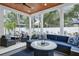 Relaxing porch with rattan furniture, fire pit and ceiling fan overlooking the backyard and swimming pool at 507 S Pine St, New Smyrna Beach, FL 32169