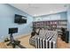 Recreation room with exercise equipment, TV, and a comfortable black and white striped sofa at 507 S Pine St, New Smyrna Beach, FL 32169