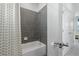 Bathroom features a bathtub with a showerhead and grey tiles at 5630 Stockade Blvd, St Cloud, FL 34771