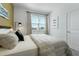 Sunlit bedroom featuring a queen bed with striped bedding, a window and decor art at 5630 Stockade Blvd, St Cloud, FL 34771