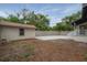 Expansive backyard featuring a concrete patio surrounded by lush greenery and a privacy fence at 622 S Ingraham Ave, Lakeland, FL 33801