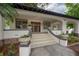 View of the front porch with decorative flowerpots and a charming art deco front door at 622 S Ingraham Ave, Lakeland, FL 33801