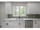 Bright kitchen featuring white cabinetry, stainless steel appliances, quartz countertops, and green subway tile backsplash at 622 S Ingraham Ave, Lakeland, FL 33801