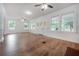 Open living room with hardwood floors, ceiling fans, and large windows providing ample natural light at 622 S Ingraham Ave, Lakeland, FL 33801