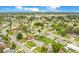 An aerial view shows a residential neighborhood with tree-lined streets, homes, and a pond in the distance at 7609 Winter Shade Dr, Orlando, FL 32822